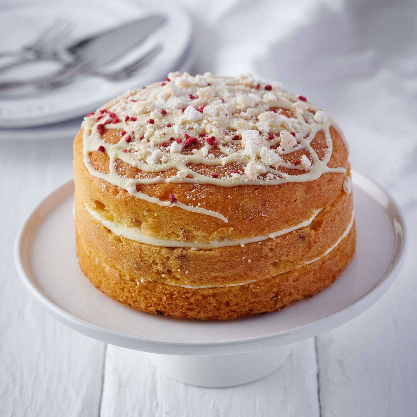 raspberry and lemon meringue cake, a 6 inch round sponge topped with white chocolate, freeze dried raspberries and crushed meringues