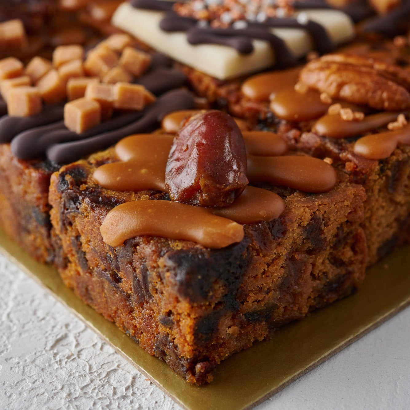 a close up photos of a salted caramel and date cake sold by the original cake company