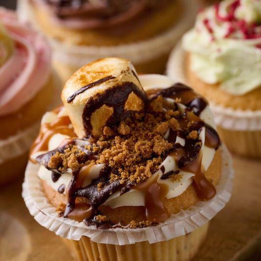 smore cupcake topped with caramel, chocolate, biscuit crumb and finished with a toasted marshmallow