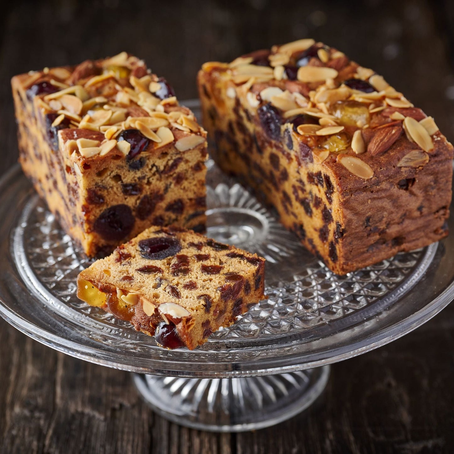 all butter fruit and nut cake topped with cherries and flaked almonds