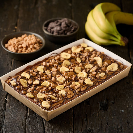 banoffee tart topped with caramel, chunks of fudge, banana chips and dark chocolate 