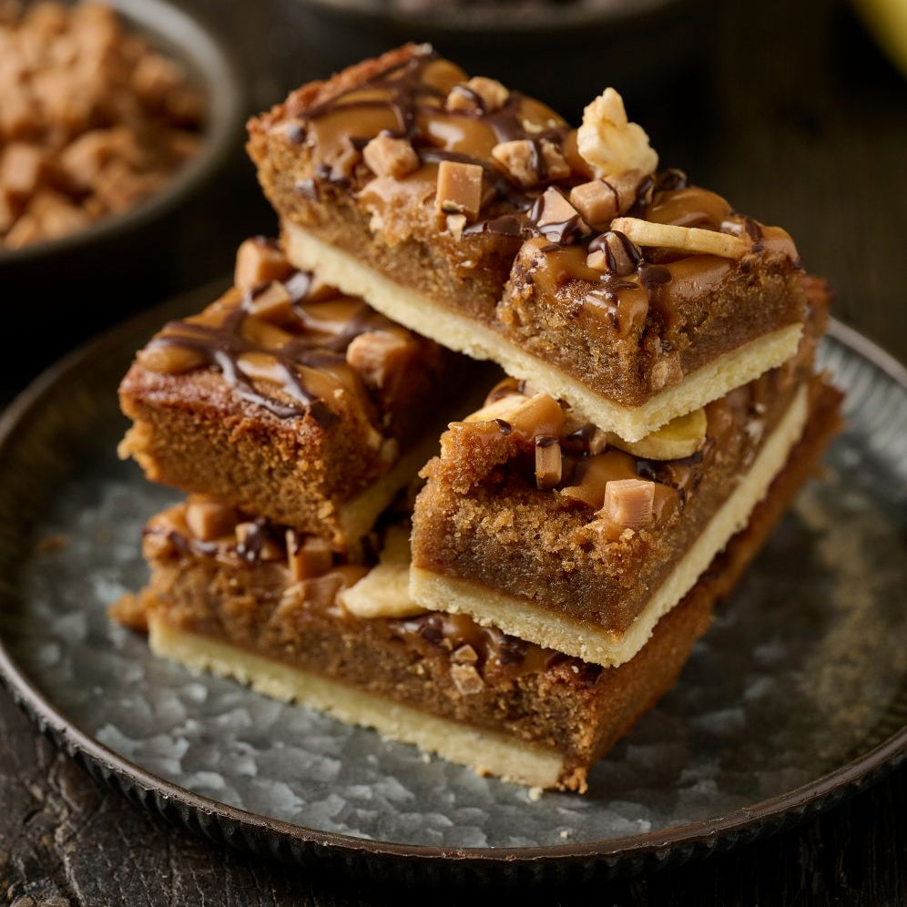 slice of banoffee tart with sweet pasry base, banana and caramel frangipane and finished with caramel, fudge and banana chips.