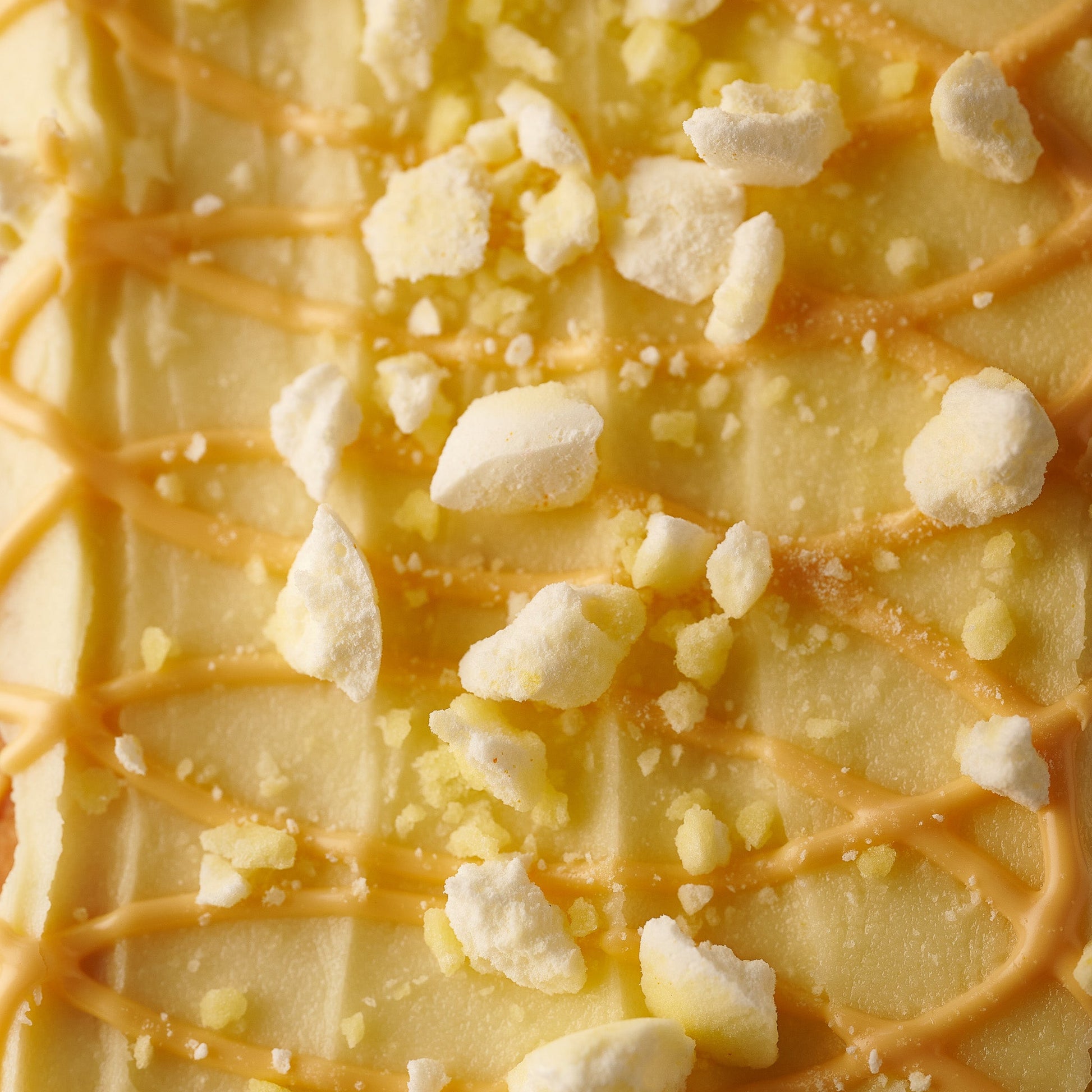 close up of orange frosting and crushed meringue on our st clements loaf cake