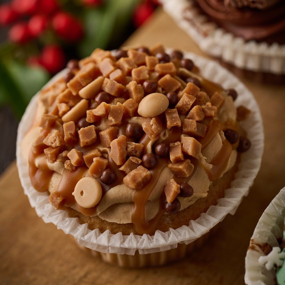 caramel crunch cupcake with whipped caramel frosting, chunks of fudge, caramel chocolate chips and crunchy chocolate balls