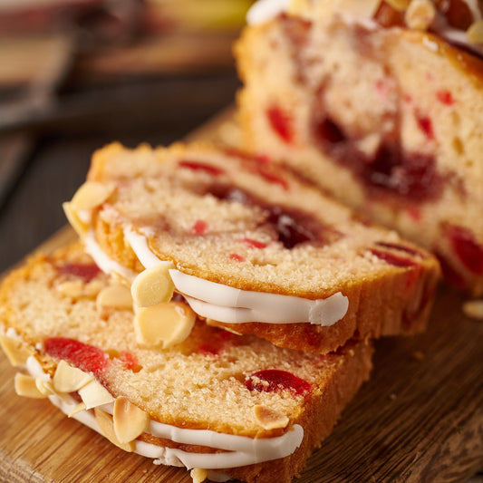 Sliced Cherry Bakewell loaf cake showing almond sponge, cherries and raspberry jam
