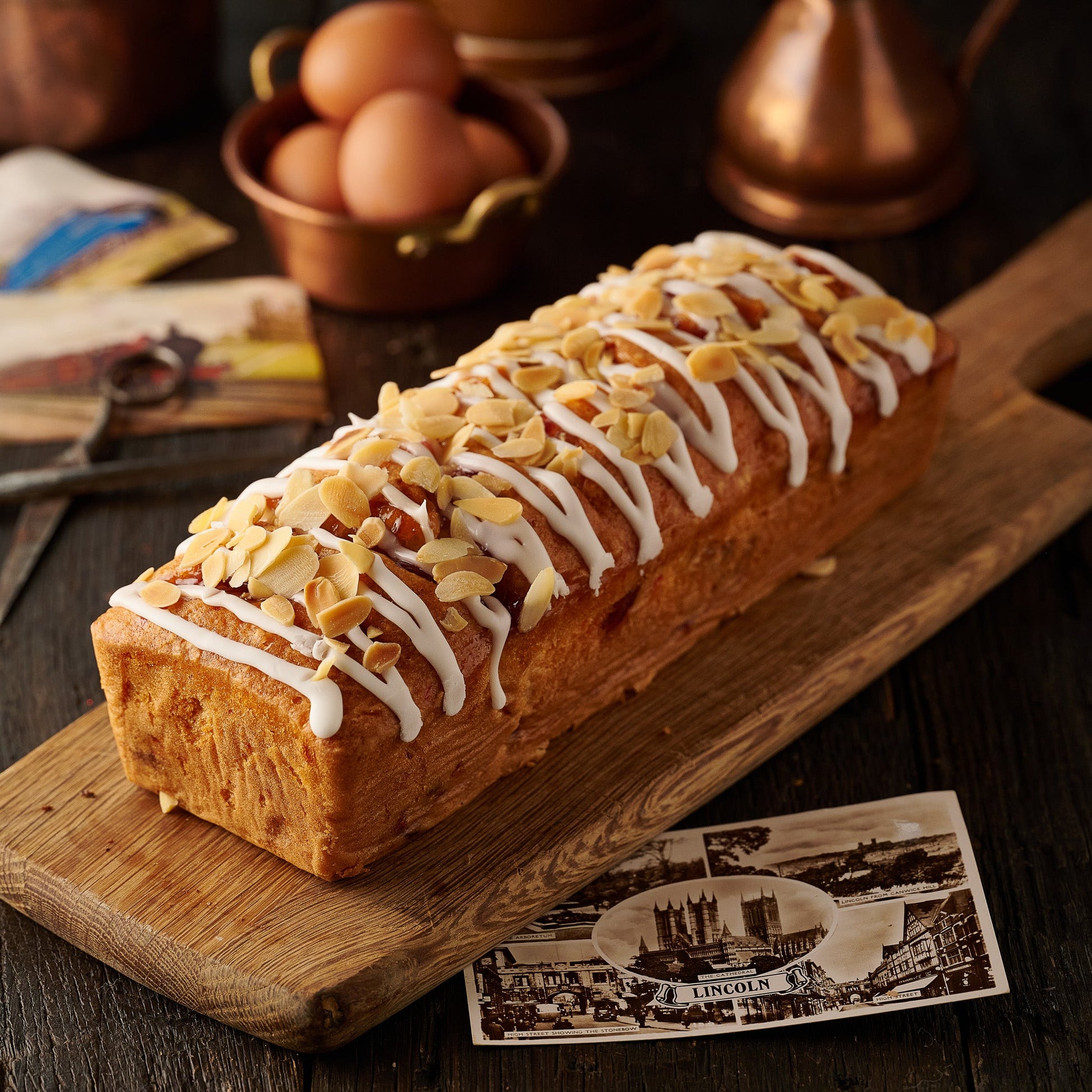 Cherry Bakewell loaf cake with icing drizzle and flaked almonds