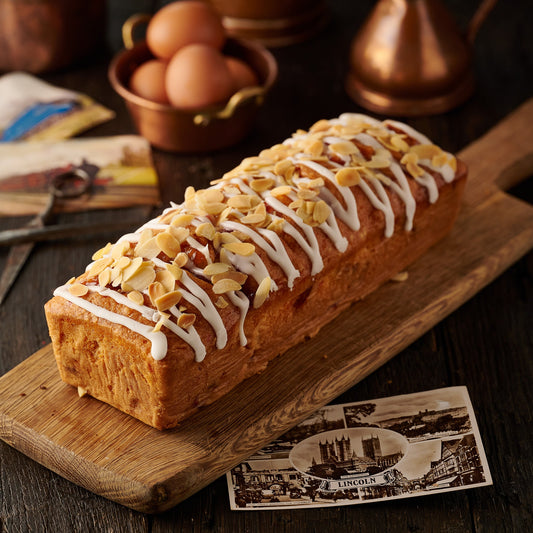 Cherry Bakewell loaf cake with icing drizzle and flaked almonds