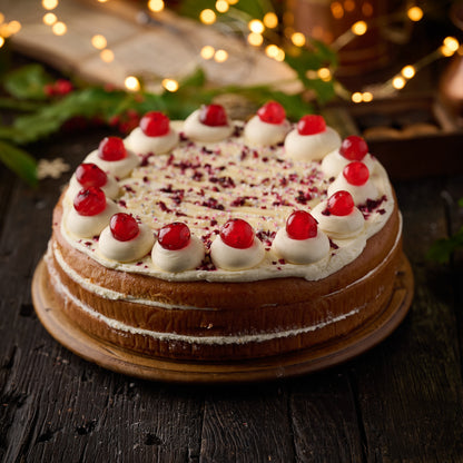 triple layered cherry and custard cake topped with vanilla frosting and glace cherries