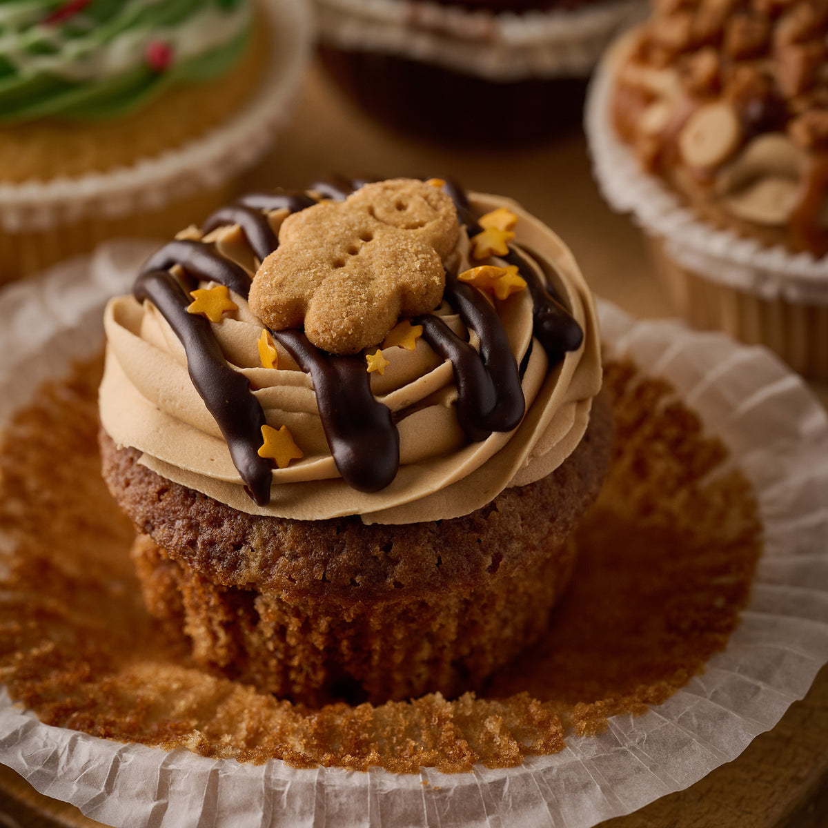 gingerbread cupcake topped with ginger frosting, chocolate drizzle and a mini gingercread man.