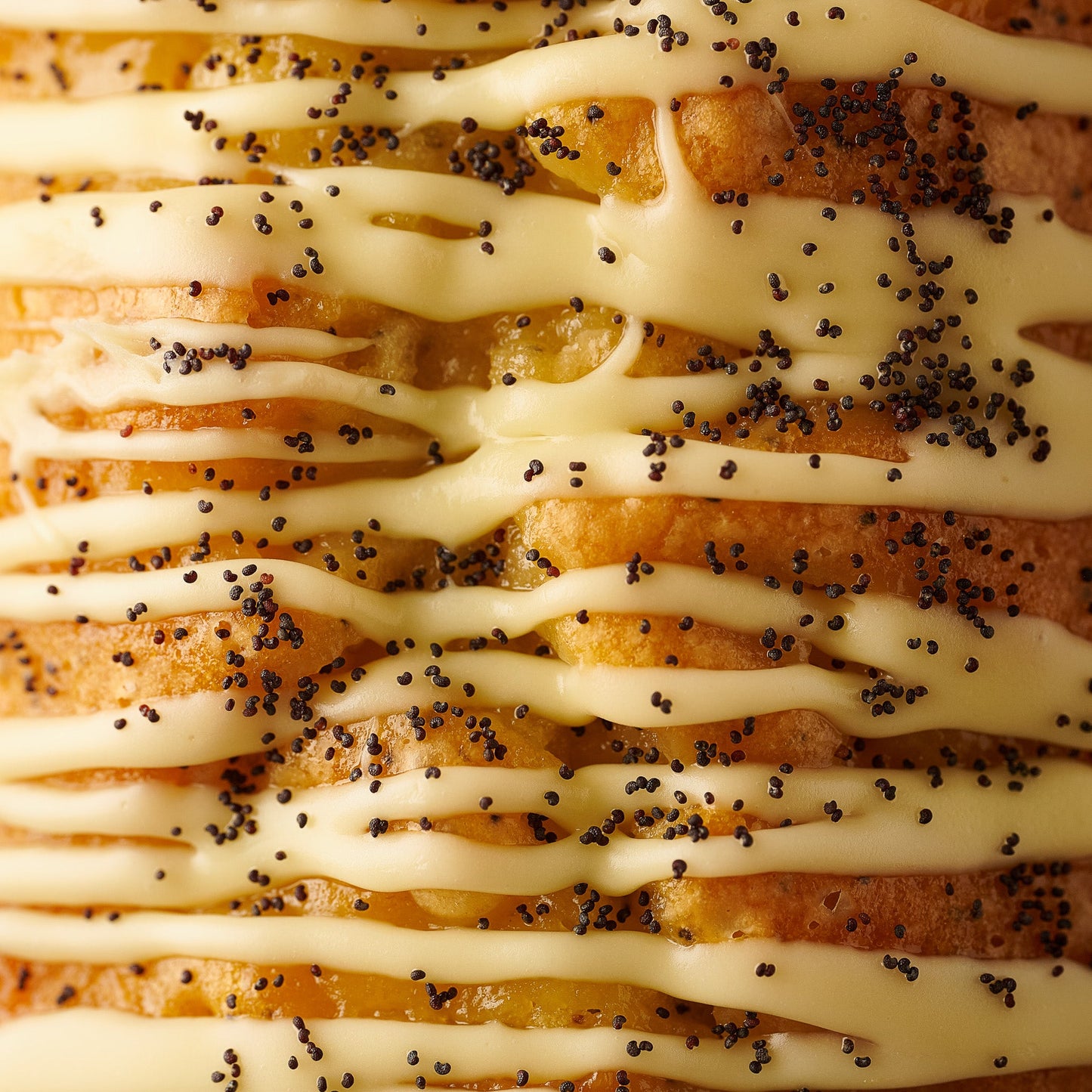 close up of lemon and poppyseed loaf cake with lemon curd, lemon fidge icing and poppyseeds