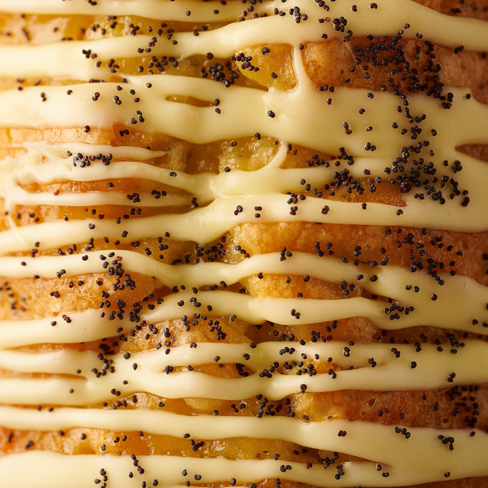 close up of lemon and poppyseed loaf cake with lemon curd, lemon fidge icing and poppyseeds