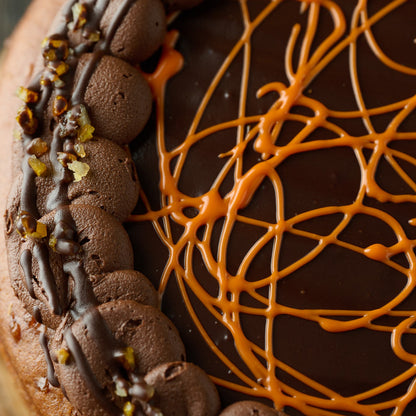 close up of our jaffa cake sponge cake with chocolate orange frosting orange chocolate drizzle and candies orange pieces. 