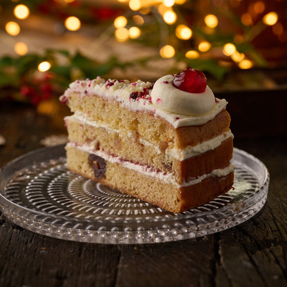 slice of vegan cherry trifle cake, canilla sponge with cherry compote and custard finished with vanilla frosting and glace cherry.