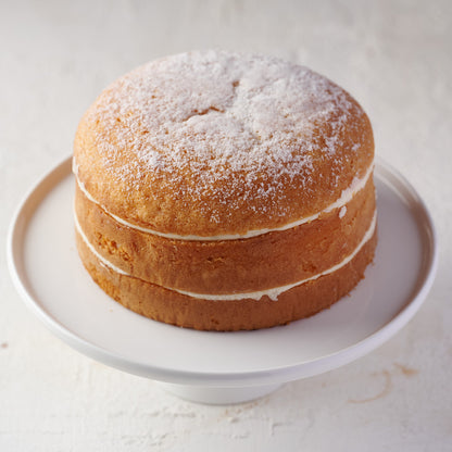 6 inch victoria sponge cake with cream cheese frosting and sugar dusting 