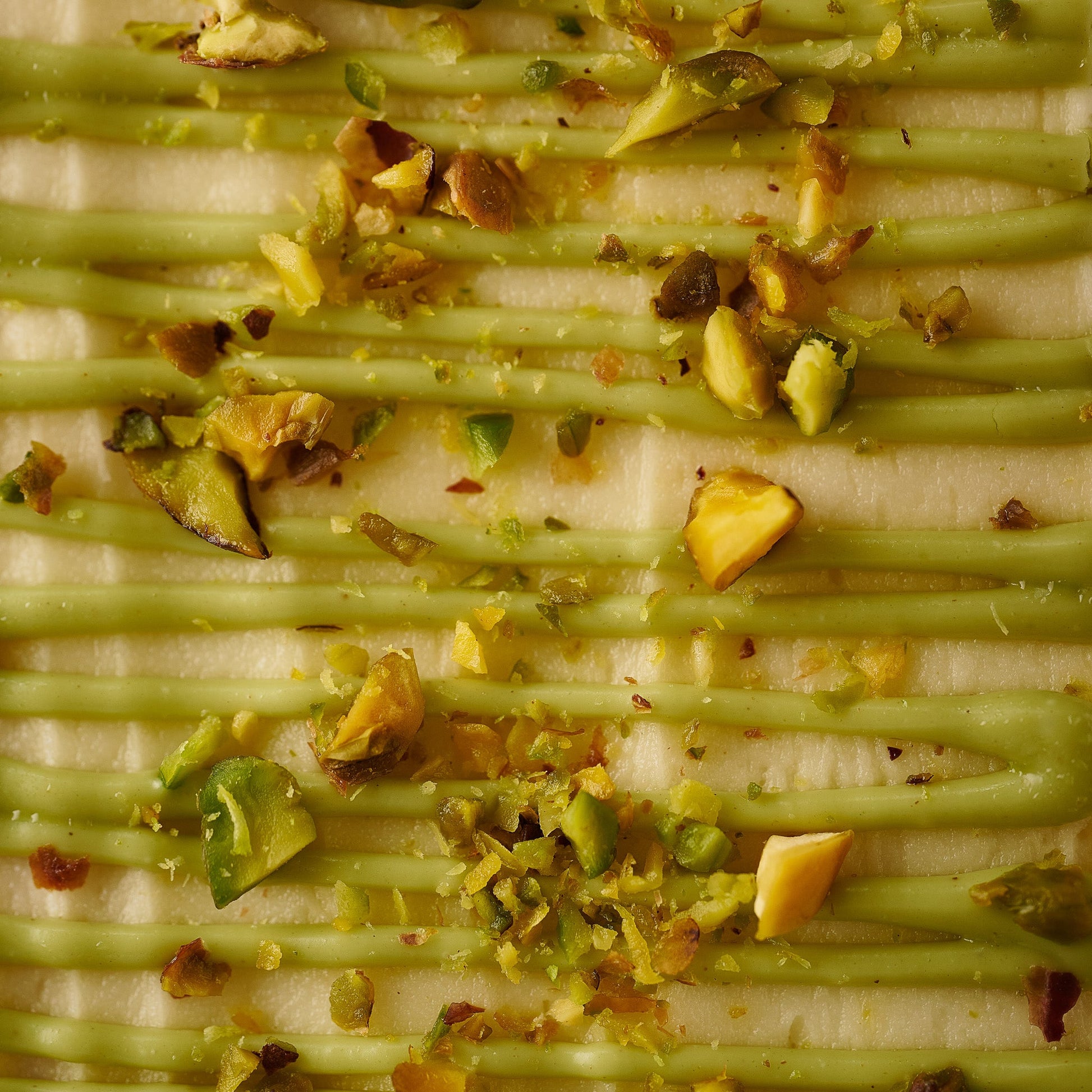 white chocolate and pistachio loaf cake close up with pistachio creamand crushed pistachio